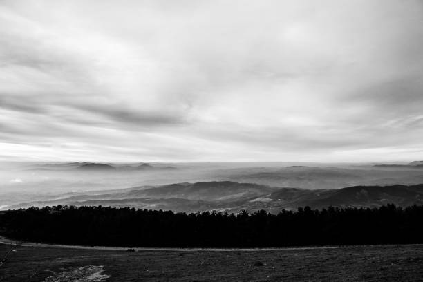 istock Subasio Mt. (Umbria, Italy), with sky covered by clouds and mist on the valley underneath 982353778