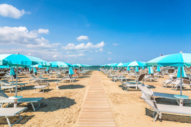 cadeiras de praia e guarda-sóis em rimini, itália, durante o dia de verão com céu azul. férias de verão e relaxar o conceito. - rimini - fotografias e filmes do acervo