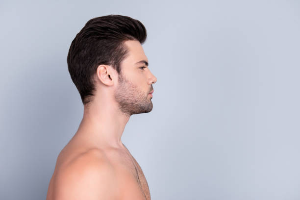 istock Profile side view half-faced portrait with copy space of athletic shirtless guy with perfect ideal skin, isolated on grey background 982355716