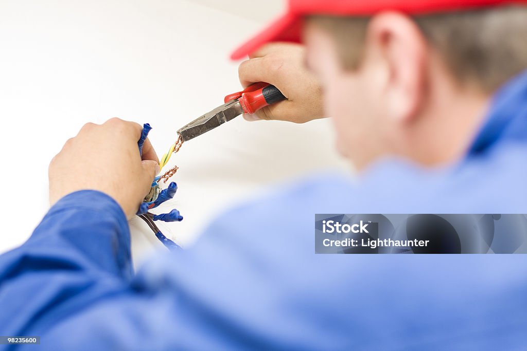 Hnadyman working with wires  Blue-collar Worker Stock Photo