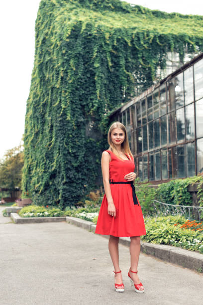 istock Blonde in bright red dress 982359520