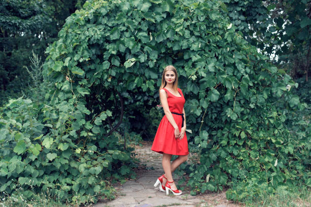 istock Blonde in bright red dress 982359740