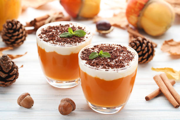 istock Pumpkin smoothie in glasses on white wooden table 982362584