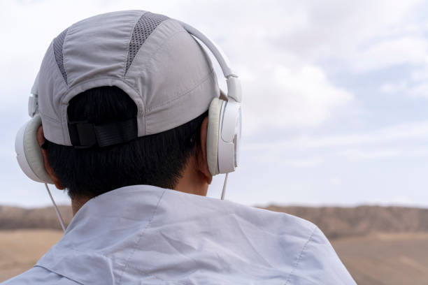 człowiek słuchający muzyki ze słuchawkami na pustyni gobi - sand dune audio zdjęcia i obrazy z banku zdjęć