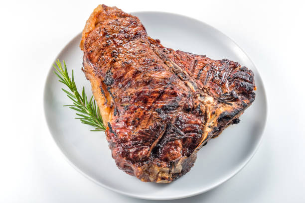 istock White round plate with Whole grilled T-bone steak and rosemary 982378682