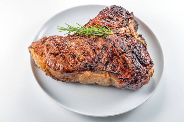 istock White round plate with Whole grilled T-bone steak and rosemary 982379206