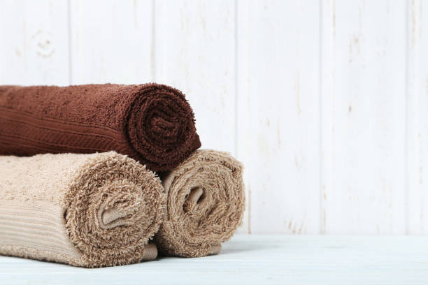 istock Beige and brown towel on white wooden table 982379282