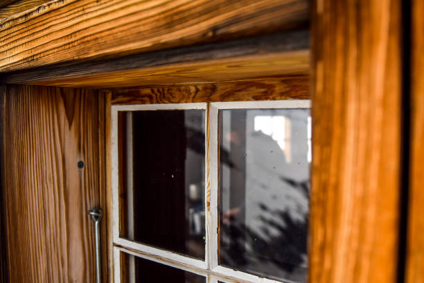 beautiful close-up view of an old, weathered wooden window with a big window frame seen at a mountain cabin in the swiss alps, switzerland. snow is reflected in the window glass. - home interior cabin shack european alps imagens e fotografias de stock