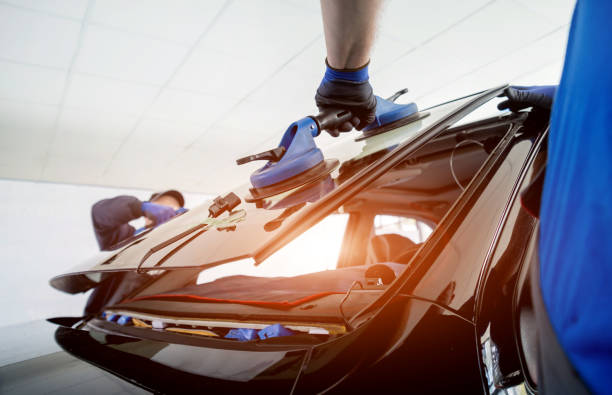 automobile special workers replacing windscreen or windshield of a car in auto service station garage. - windshield imagens e fotografias de stock