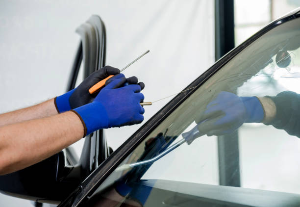 istock Automobile special workers remove old windscreen or windshield of a car in auto service station garage. 982384984