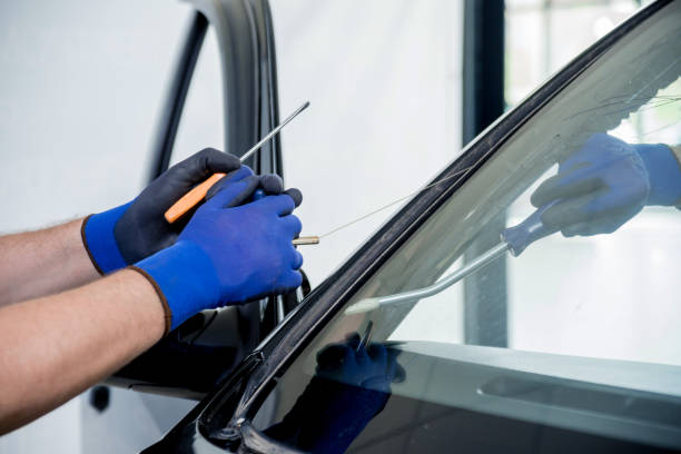 istock Automobile special workers remove old windscreen or windshield of a car in auto service station garage. 982387510