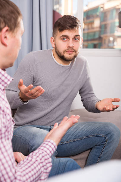 istock Troubled man talking with friend on sofa 982388176
