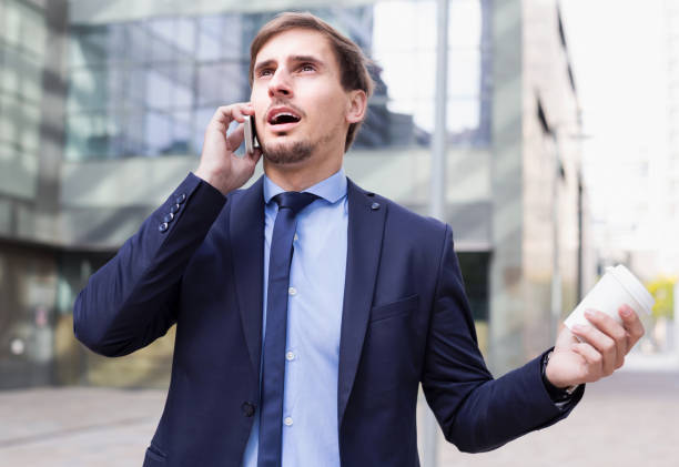 istock Positive male worker talking on the phone with coffee 982389102