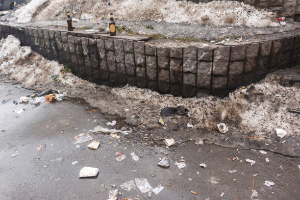 2 bottles of beer and a lot of garbage butts cellophane paper on the snowy parapet 2 bottles of beer and a lot of garbage butts cellophane paper on the snowy parapet. Lots of garbage on the snow street near the shops purchase of steel scrap stock pictures, royalty-free photos & images