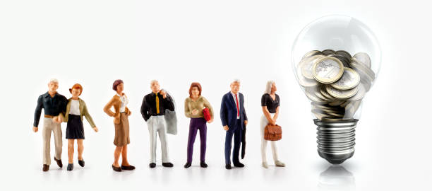 istock Miniature people in front a light bulb with Euro coins inside 982390056