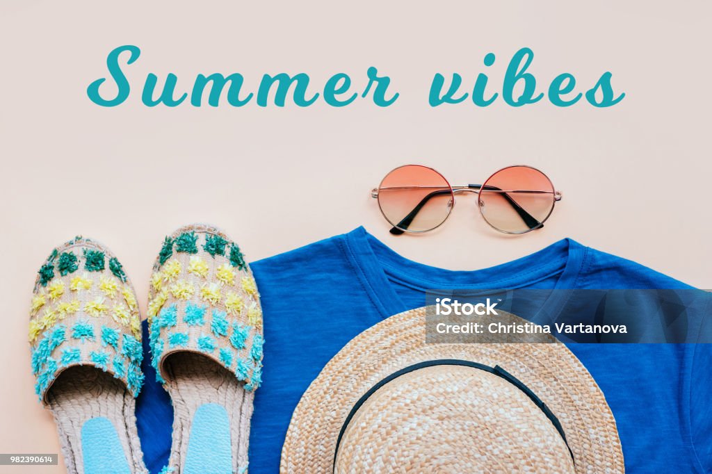 Summer fashion flatay Summer fashion flatlay with gradient round sunglasses, straw hat, espadrille sandals and t-shirt on the beige background. Perfect beach set for holidays on the sea. Marina style. Summer vibes. Espadrilles Stock Photo