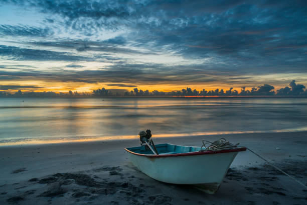 istock A beautiful tropical dawn with a boat on beach 982404468