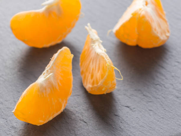 istock Tangerines slices on black background. Orange mandarin 982419132