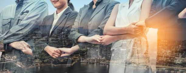 istock Double exposure business people holding hands. 982437280