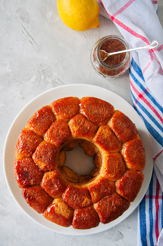 Homemade caramel monkey bread with brown sugar and lemon zest on a white stone background