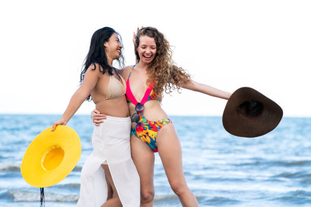 istock Happy women dance on sand beach in summer. 982444034