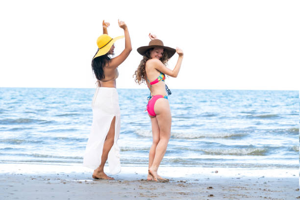 istock Happy women dance on sand beach in summer. 982444052