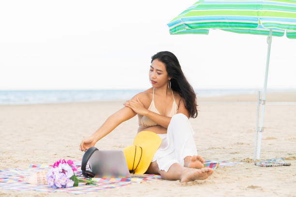 istock Plus size young woman sitting on the beach. 982444076