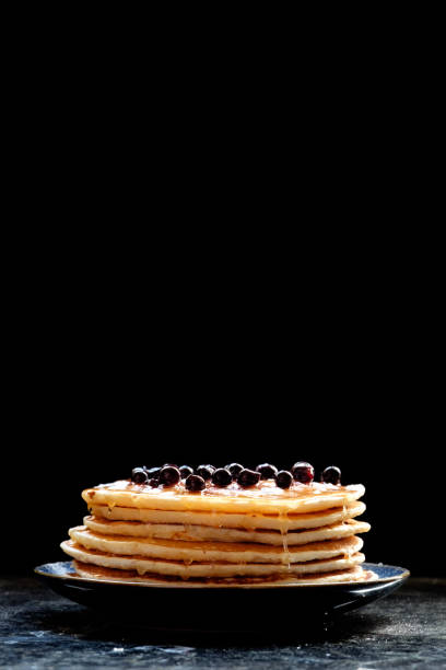 istock Stack of pancakes with black currant berries and honey. 982466182