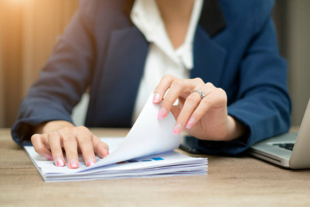 istock Female office workers holding are arranging documents of unfinished documents on office desk, Stack of business paper. 982487772