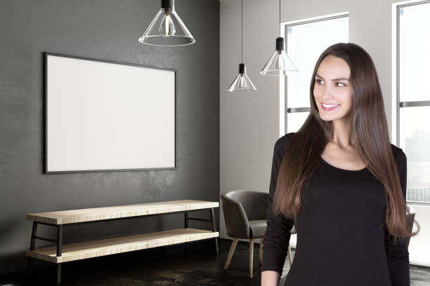 istock Attractive woman in hallway with poster 982496642