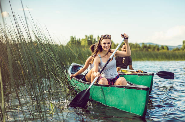 giovane donna canoa sul lago - men sitting canoe canoeing foto e immagini stock