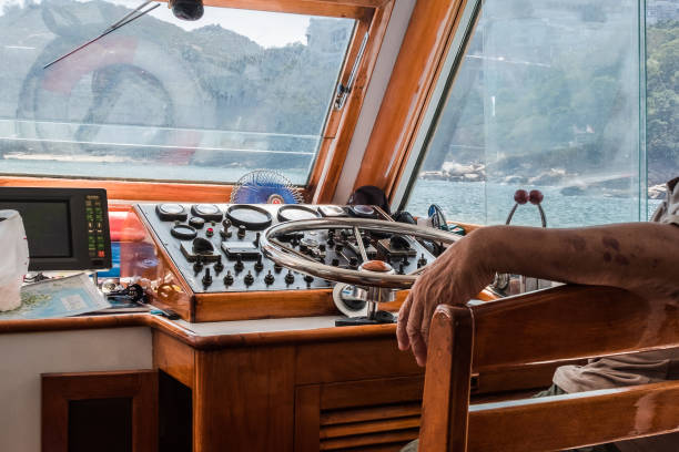 istock Navigation Console With Metal Steering Wheel Inside The Motorboat Deck House. Boat Driver Sitting Near The Wheel. Dirty Windows Splashing With Sea Water. 982498124