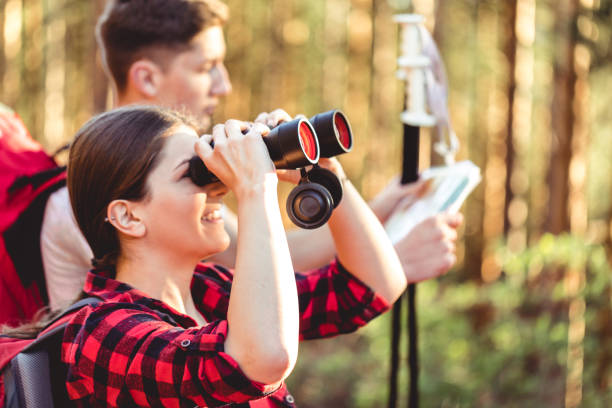 istock Cute girl using binoculars in forest while on hiking 982503260
