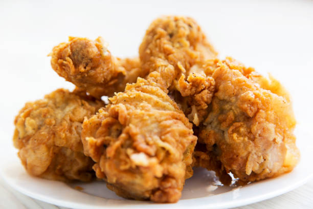 istock Fried chicken drumsticks on a white plate, close-up. 982503326