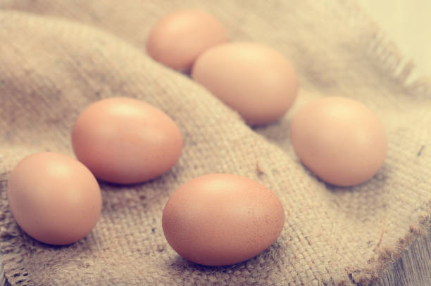 uova di gallina fresche su tavolo di legno - agriculture brown burlap cholesterol foto e immagini stock