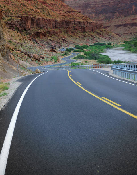 istock Winding Utah road, mountains and river in background 982513356