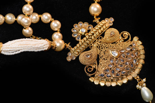 istock Heavy Golden pendant with beads and pearl set closeup image on black background 982513800
