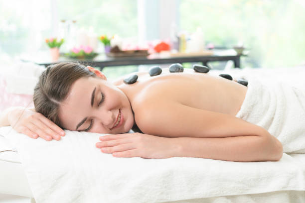 istock Hot stone massage treatment by therapist in spa. 982514058