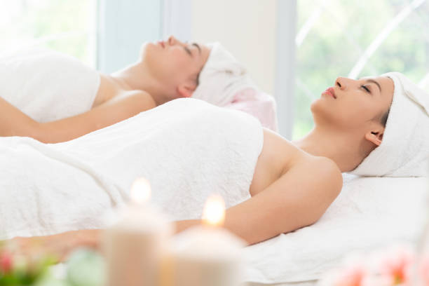 istock Relaxed young woman lying on spa bed for massage. 982514110