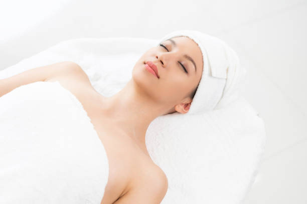 Relaxed young woman lying on spa bed for massage.