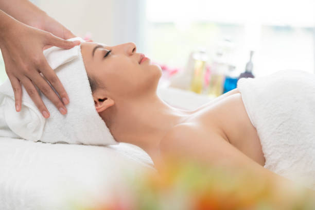 istock Relaxed young woman lying on spa bed for massage. 982514162