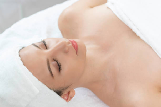 istock Relaxed young woman lying on spa bed for massage. 982514174