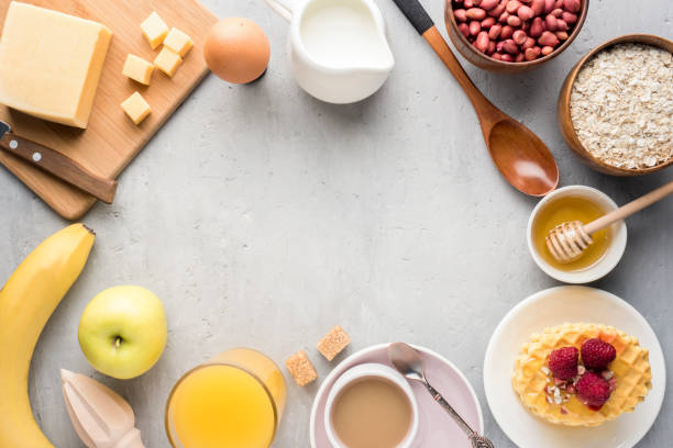 istock Healthy Breakfast Cheese Juice coffee Honey Peanuts Egg Biscuits Waffles Cereal Oatmeal Apple Banana. Selective focus. The view from the top. Flat position 982518988