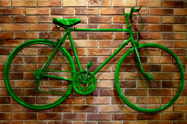 istock Green bicycle on a brick wall. Unusual beautiful pink tones. 982524690