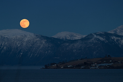 Full moon over a fjord
