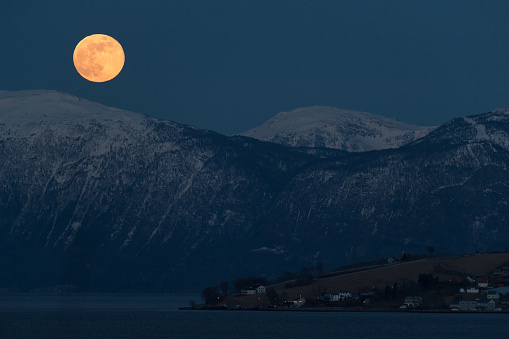Full moon over a fjord