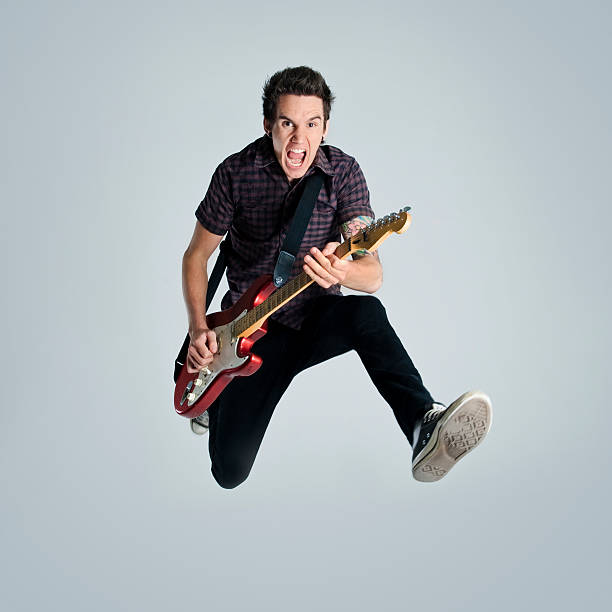 istock Man playing guitar jumping in the air 98253723