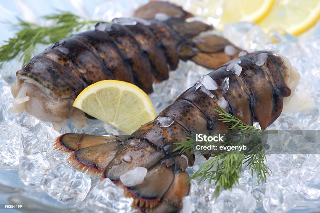 Raw lobster tails Closeup of delicious raw lobster tails on ice ready for cooking. Artificial Ice Stock Photo