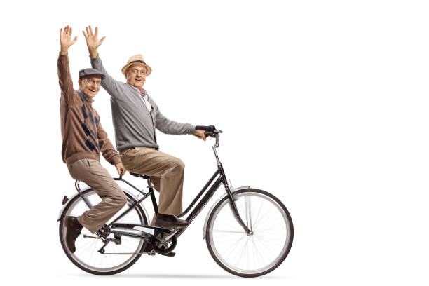 istock Seniors riding on a bicycle and waving at the camera 982550030