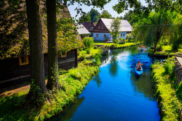 Holiday Spreewald cruise in Lübbenau/Lehde, Germany Lehde, Germany - August 01, 2017:People kayaking on one of the beautiful channels in the Lübbenau/Lehde area in the beautiful Spreewald, Germany. The Spreewald forest consists of over 200 small canals and waterways of the river Spree which are cutting their way through meadows, calm forest areas and along traditional farmhouses. In 1991 it was designated as biosphere reserve by UNESCO. spreewald stock pictures, royalty-free photos & images